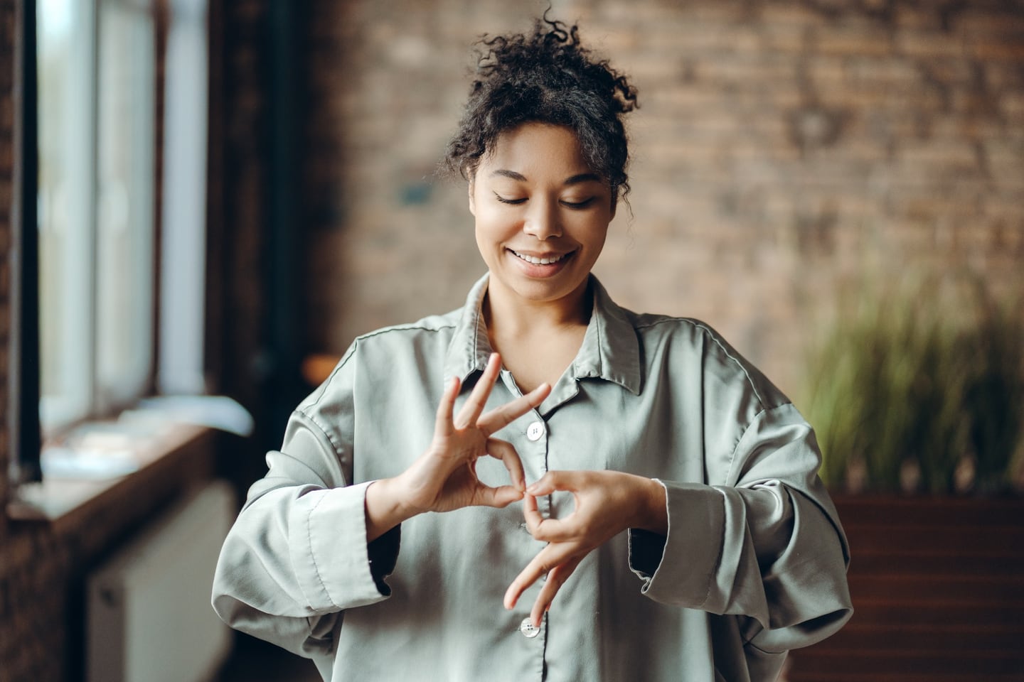 Femme communiquant en langue des signes dans un intérieur lumineux