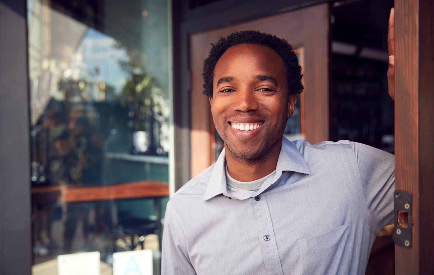Man smiling in a workplace doorway