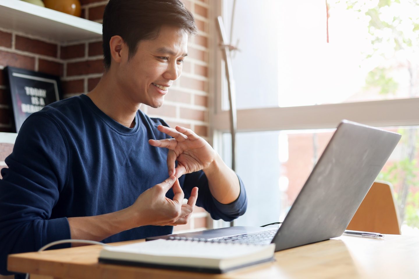 Sign language professional providing a remote service from a laptop