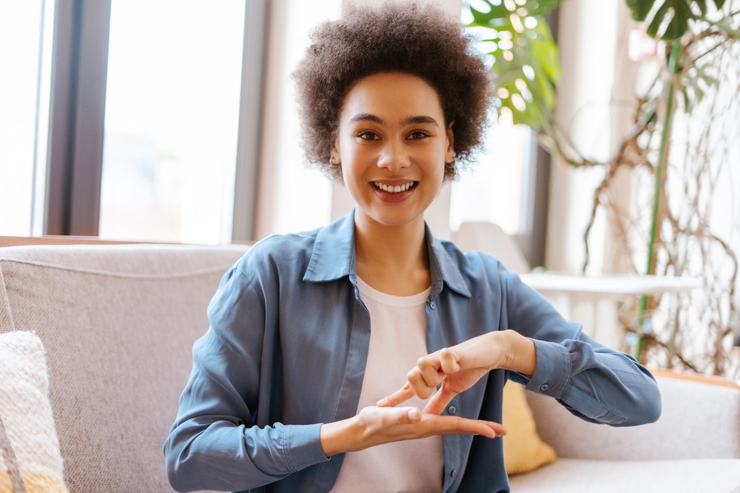 Woman communicating in sign language beside a window
